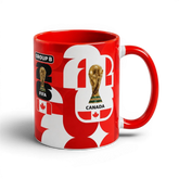 Fann Bliss Canada Soccer World Cup ceramic mug in red and white with FIFA trophy and Canadian flag graphics.