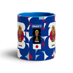 Fann Bliss ceramic coffee mug featuring Japan World Cup branding, FIFA trophy, and blue, white, and red geometric art.