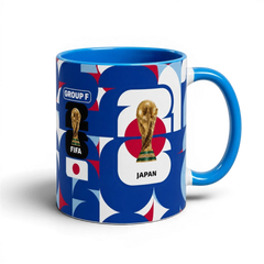 Fann Bliss ceramic coffee mug featuring Japan World Cup branding, FIFA trophy, and blue, white, and red geometric art.