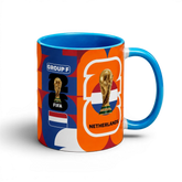 Fann Bliss Netherlands World Cup commemorative ceramic coffee mug with orange, blue, and white abstract pattern, FIFA trophy, and flag.