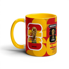 Fann Bliss Spain FIFA World Cup commemorative ceramic mug in red and yellow with trophy and flag graphics.