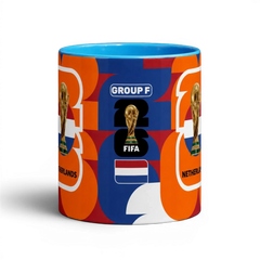 Fann Bliss Netherlands World Cup commemorative ceramic coffee mug with orange, blue, and white abstract pattern, FIFA trophy, and flag.