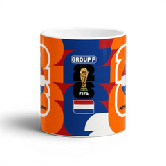 Fann Bliss Netherlands FIFA World Cup commemorative ceramic mug with orange, white, and blue geometric pattern.