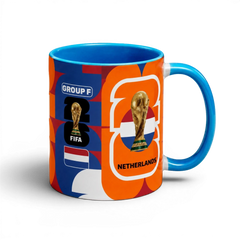 Fann Bliss Netherlands World Cup commemorative ceramic coffee mug with orange, blue, and white abstract pattern, FIFA trophy, and flag.